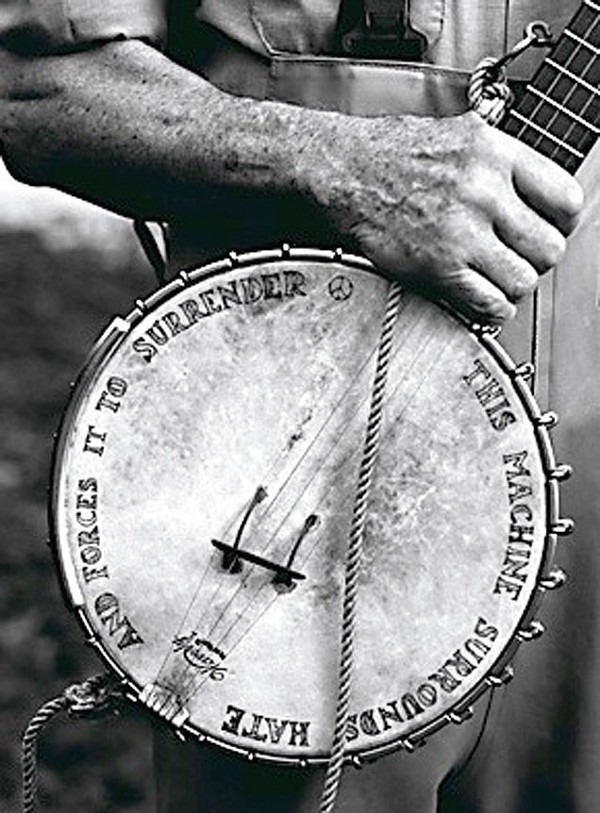 Pete Seeger's banjo says "This Machine Surrounds Hate and Forces it to Surrender."